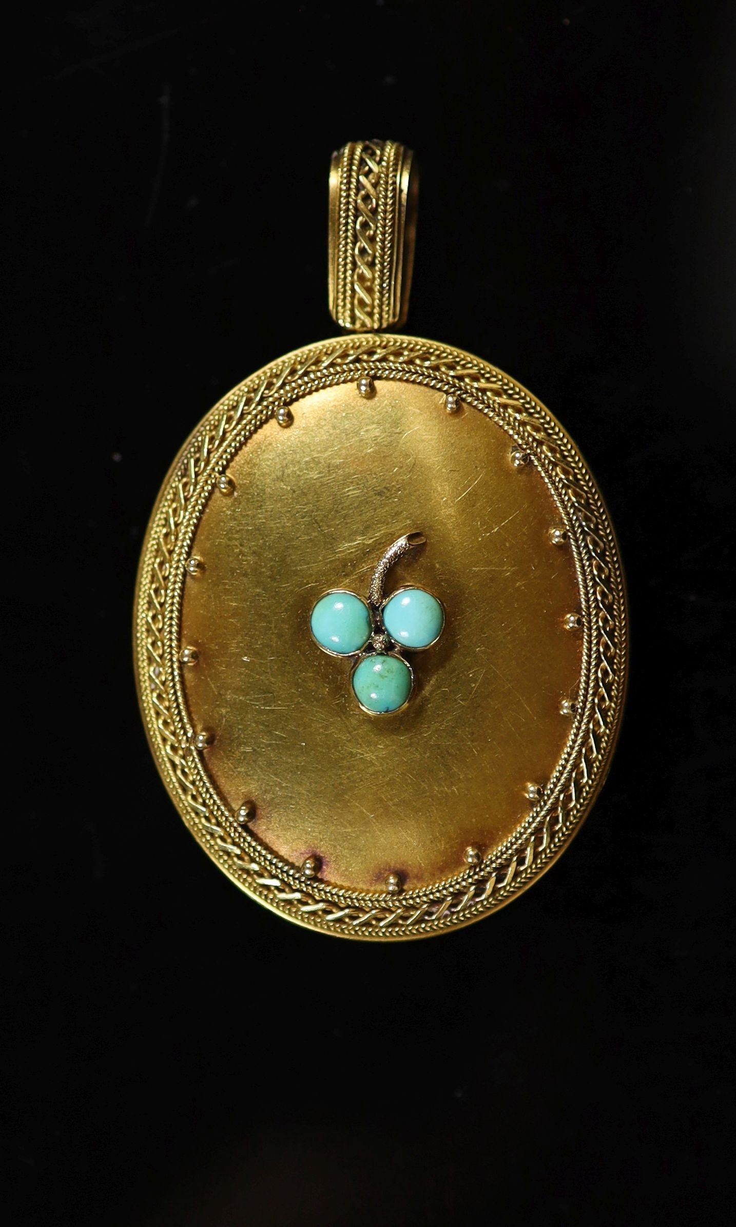 A Victorian gold and three stone turquoise set oval locket